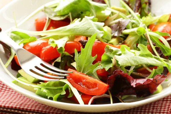 Mescolare l'insalata (rucola, iceberg, barbabietola rossa) in una ciotola sul tavolo — Foto Stock