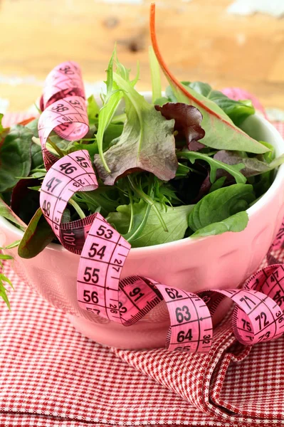 Meng salade (rucola, ijsberg, rode biet) met een roze meetlint — Stockfoto