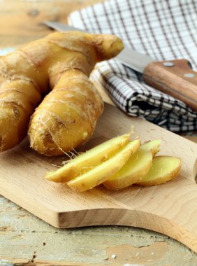 Fresh ginger root on a cutting board clipart