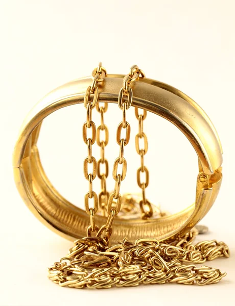 Joyas, pulseras y cadenas de oro sobre fondo blanco — Foto de Stock