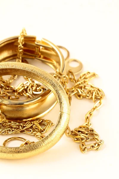 Золотые украшения, браслеты и цепи на белом фоне — стоковое фото