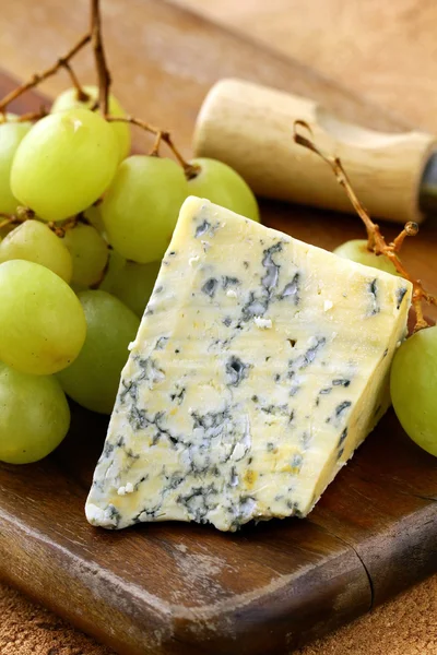 stock image Blue cheese and white grapes on a wooden board