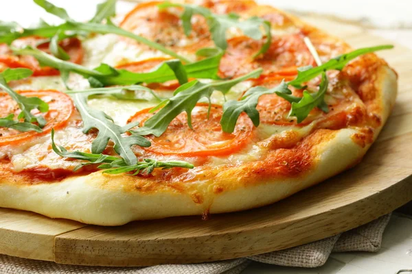 Margarita pizza with tomatoes and with arugula, on the board — Stock Photo, Image