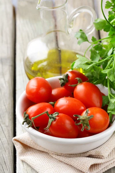 Tomates cherry, aceite de oliva y perejil sobre fondo de madera —  Fotos de Stock