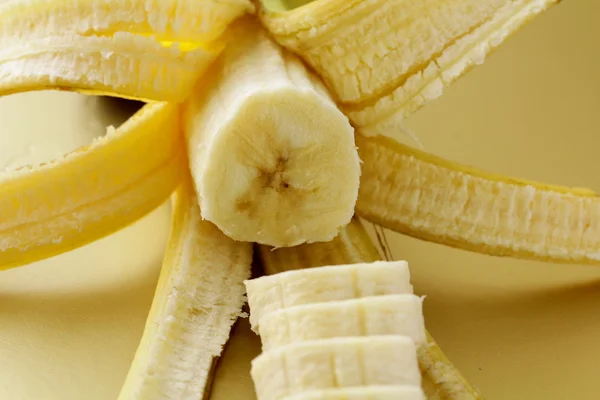Ripe banana cut into slices on a gold background — Stock Photo, Image