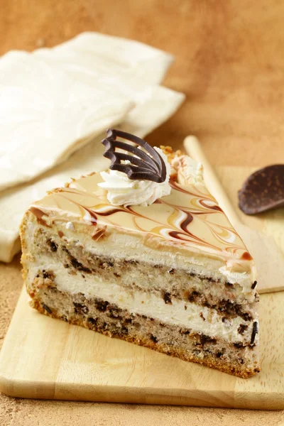 Pedazo de pastel de caramelo crema con chocolate en una tabla de madera — Foto de Stock
