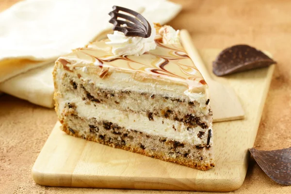 Piece of cream caramel cake with chocolate on a wooden board — Stock Photo, Image