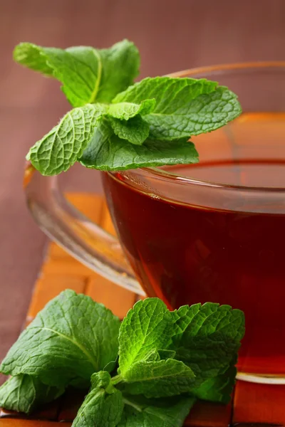 Kopp te med mynta på brun bakgrund — Stockfoto