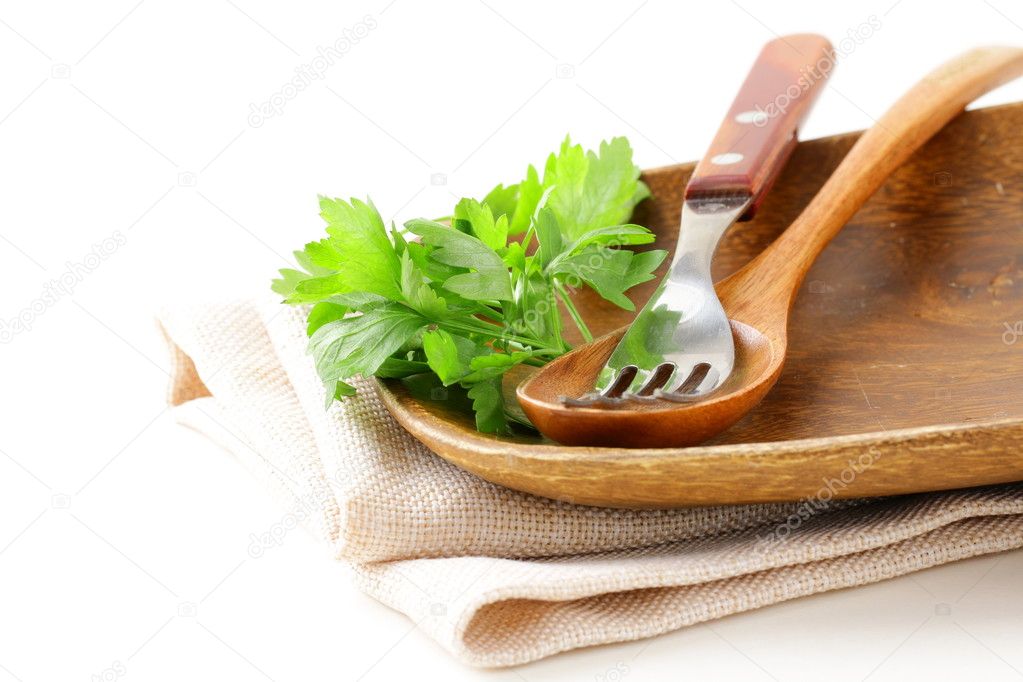 Wooden plate and cutlery on a white background