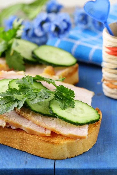 Smörgås med skinka och gurka på en trä skärbräda — Stockfoto