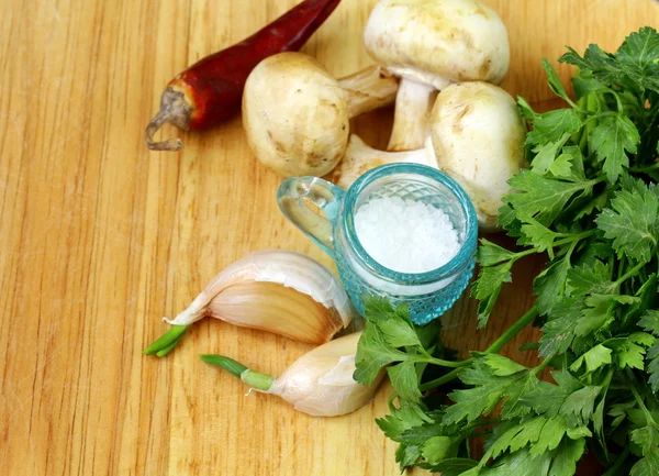Bawang putih, jamur, cabai, peterseli, mentimun dan rempah-rempah di atas papan potong — Stok Foto