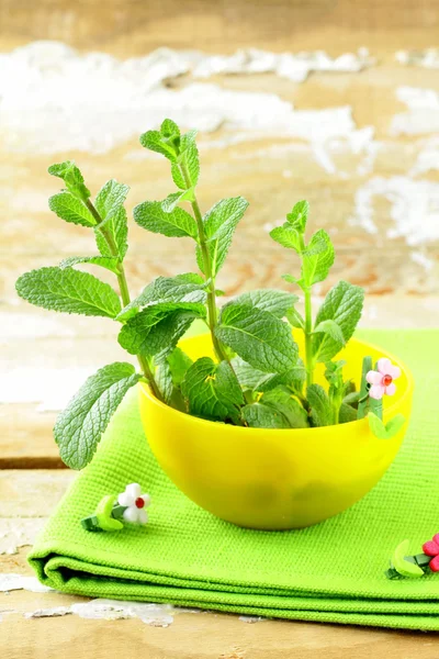 Bunch of fresh green mint in a yellow cup — Stock Photo, Image