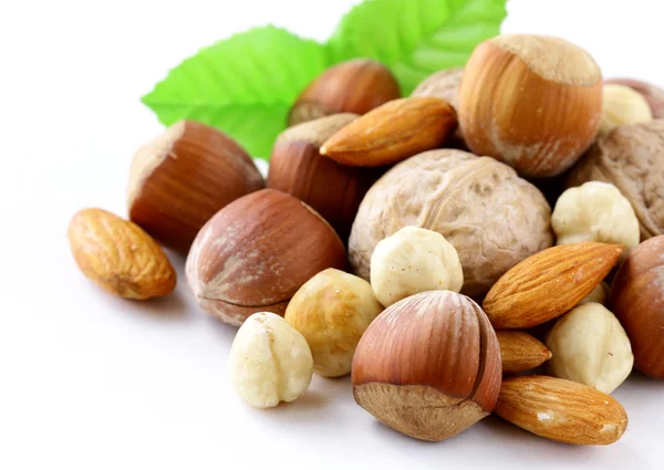Směs ořechů - vlašské ořechy, lískové ořechy, mandle na bílém pozadí — Stock fotografie