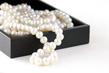 Macro pearls in black gift box clipart