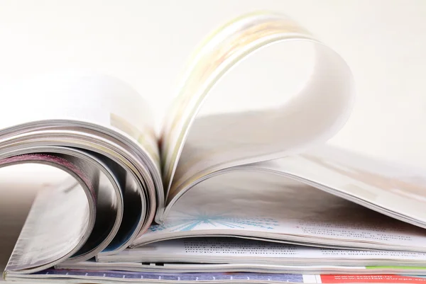 Empilhar revistas abertas em um fundo branco — Fotografia de Stock