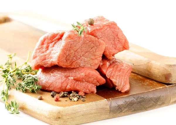 Carne crua fresca com tomilho e especiarias em uma tábua de corte — Fotografia de Stock
