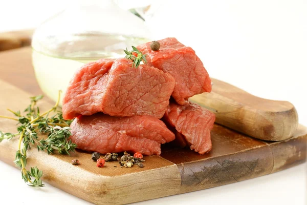 Carne fresca cruda con tomillo y especias en una tabla de cortar —  Fotos de Stock