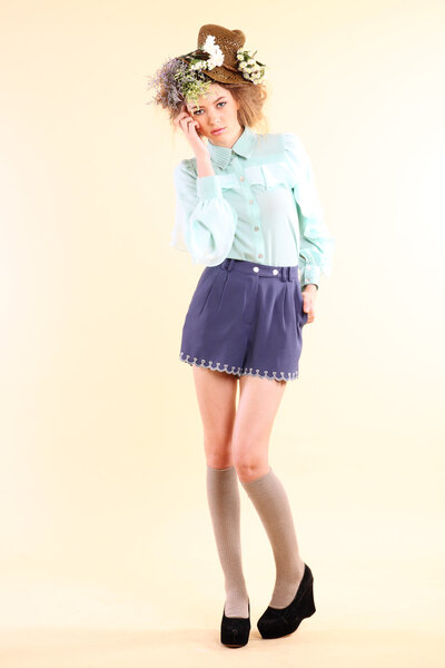 Мода модели весной позирует в светло-бежевом фоне
