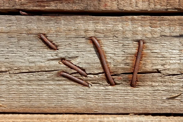 Іржаві цвяхи в дерев'яному щиті — стокове фото