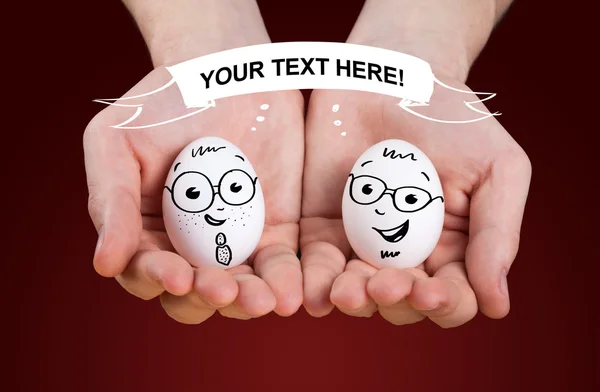 Male hand holding holding eggs with smiley faces — Stock Photo, Image