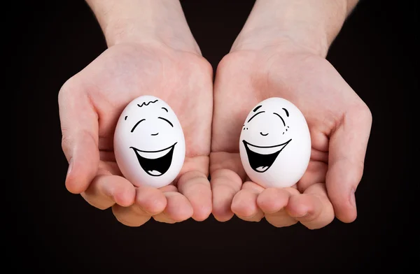 Male hand holding funny eggs — Stock Photo, Image