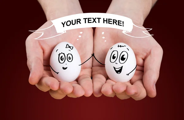 Male hand holding holding eggs with smiley faces — Stock Photo, Image