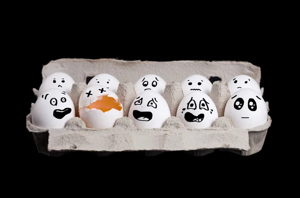 Grupo de ovos sorridentes em caixa com ovo quebrado no fundo preto — Fotografia de Stock