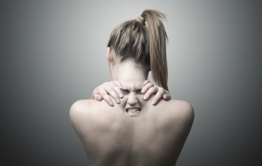 Boyun ağrısını gösteren bir kadının arkası.