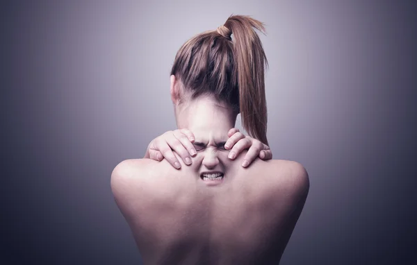 Espalda de una mujer que indica dolor de cuello —  Fotos de Stock