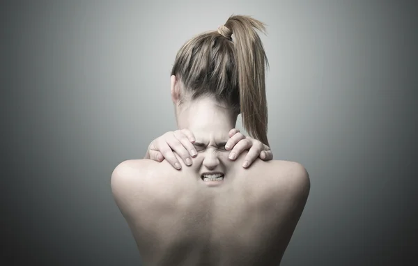 Спина женщины, указывающая на боль в шее — стоковое фото