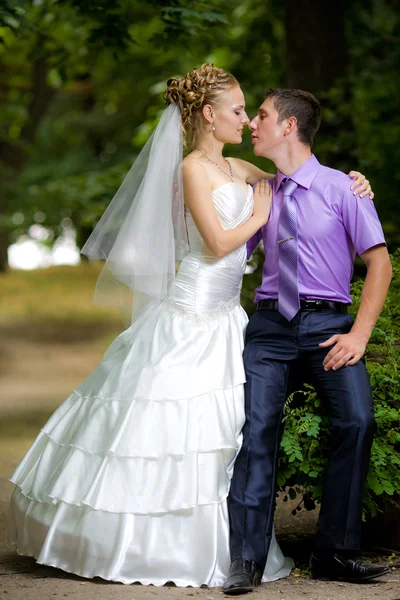 Noiva e noivo com um buquê de olhar um para o outro — Fotografia de Stock