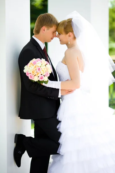 Bruden och brudgummen i armarna — Stockfoto