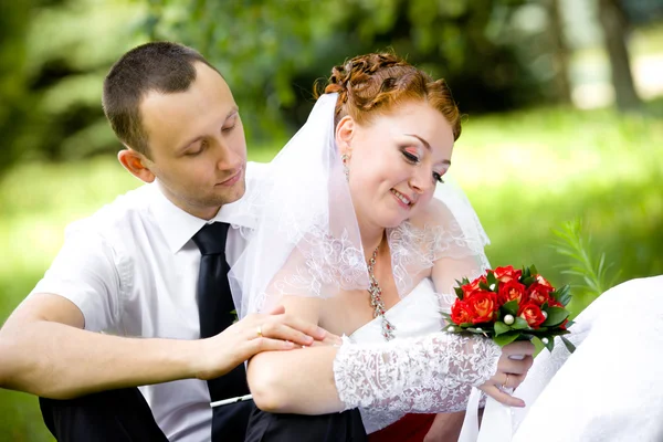 Наречений і наречений сидять на траві — стокове фото