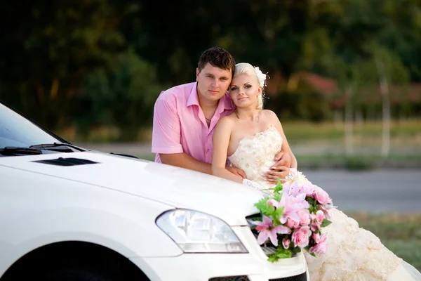 Bruden och brudgummen nära bilen — Stockfoto