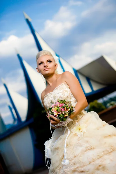 Bela noiva jovem com um buquê na natureza — Fotografia de Stock