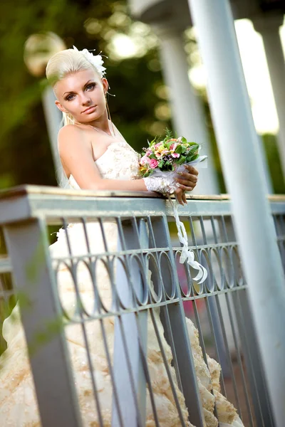 Bela noiva jovem com um buquê na natureza — Fotografia de Stock