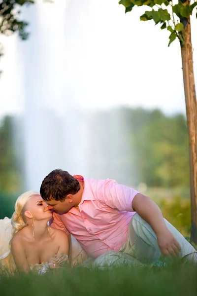 Mariée et marié avec un bouquet de baisers sur la nature — Photo