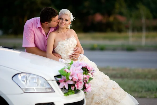 Bruden och brudgummen nära bilen — Stockfoto