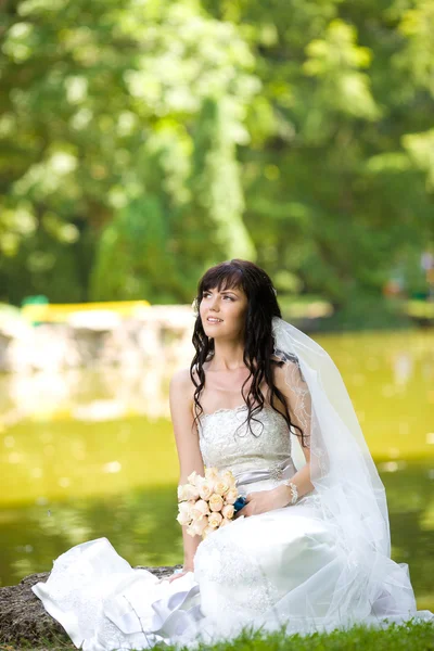 Bella giovane sposa con un bouquet sulla natura — Foto Stock