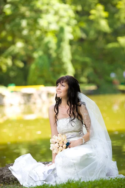 Красивая молодая невеста с букетом на природе — стоковое фото