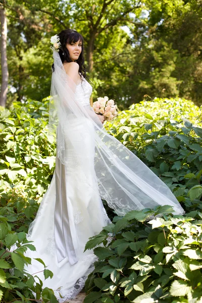 Schöne junge Braut mit einem Strauß auf die Natur — Stockfoto