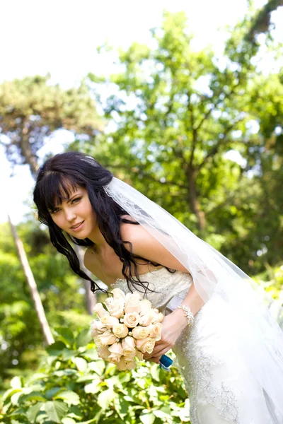 Bella giovane sposa con un bouquet sulla natura — Foto Stock