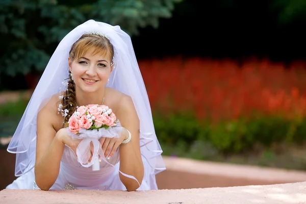 Uma noiva bonita no vestido de casamento branco . — Fotografia de Stock