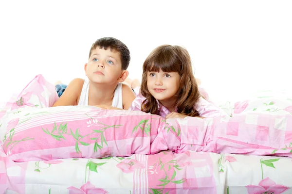 Malou holčičku a chlapce, sedí na posteli — Stock fotografie