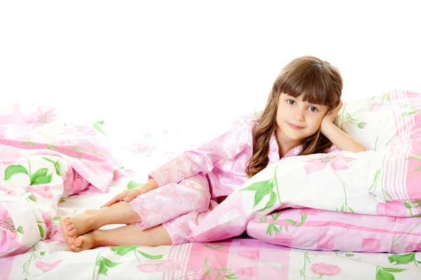 Een klein meisje liggend op het bed Stockfoto