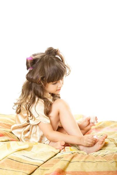 Una niña sentada en una cama Fotos de stock libres de derechos