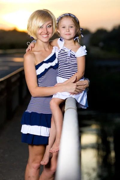 Mor och dotter spelar på flodbank — Stockfoto