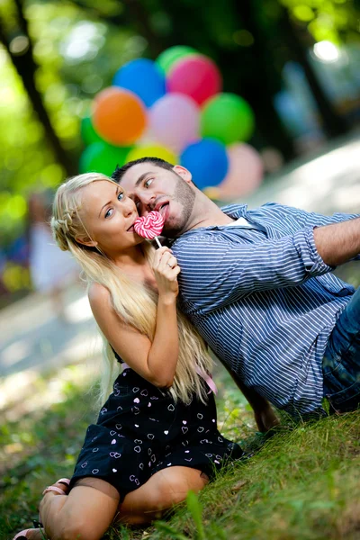 Young loving couple with balloons on natural background — Stock Photo, Image