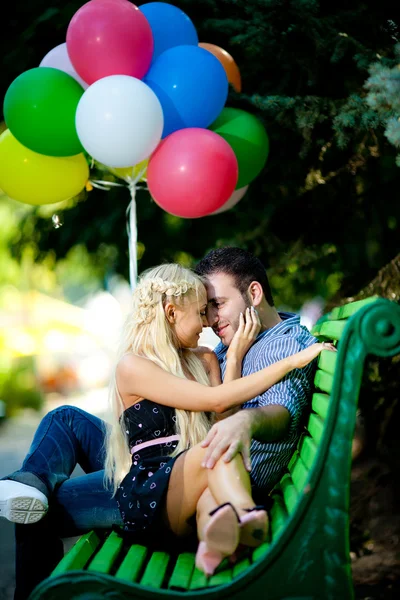 Молодая любящая пара с воздушными шарами на естественном фоне — стоковое фото
