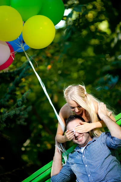 Young loving couple with balloons on natural background — Stock Photo, Image